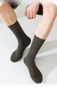 Détail de chaussettes montantes côtelées marron foncé en coton pour homme porté