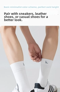 Detail of white crew sock featuring a pixel logo and ribbed cuffs on foot