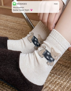 Close-up of warm wool blend socks featuring a cute cartoon bear in cozy home setting