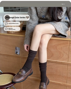 Detailed view of dark brown vertical ribbed knit crew socks worn with loafers