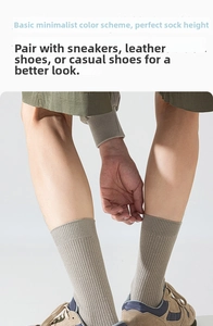 Détail de chaussettes en coton côtelé vert kaki portées avec baskets rétro et short cargo