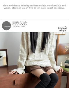 Detail of cream cable-knit sweater paired with black over-the-knee socks for winter