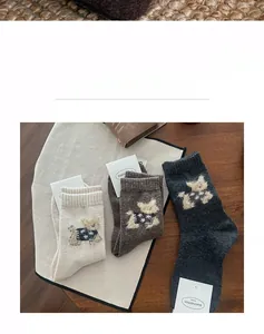 Detail of wool socks with cute dog embroidery on breathable knit fabric texture