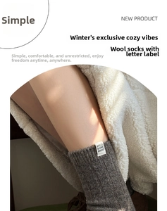 Detail of grey wool socks featuring vertical rib knit and branded fabric label accent