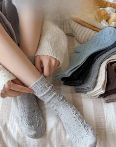 Macro detail of thick wool socks showing vintage cable knit patterns in various colors