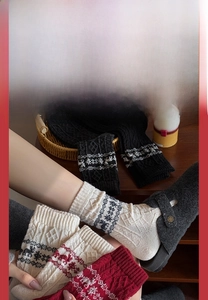 Close-up of Fair Isle knit Christmas socks with reindeer and snowflake patterns