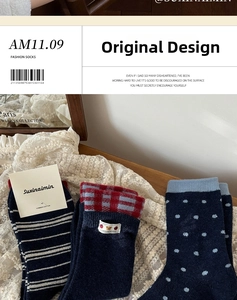 Close-up of three dark blue combed cotton socks with bear patch, stripes, and dots on lace