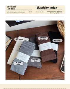 Detail of ribbed knit over-knee socks in five colors on a wooden surface