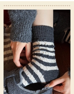 Gros plan détaillé de chaussettes en laine à rayures gris foncé et blanc cassé épais
