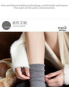 Detail von dunkelgrauen Rippstricksocken mit dicker Textur und warmen Lifestyle-Requisiten