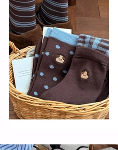 Detail of knitted mid-calf socks with cute puppy embroidery and blue polka dot patterns