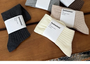 Detailed texture of ribbed cotton crew socks in earth tones on a wooden surface