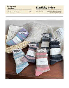 Detail of six colorful thick striped wool socks in a cozy home setting with warm decor