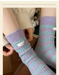 Detail of wool blend striped socks with woven label and cozy knitted texture