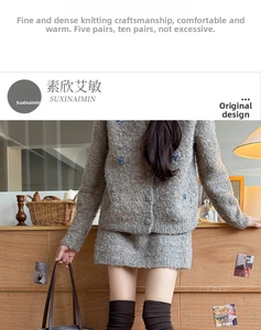 Close-up of grey knit cardigan with blue sequin floral embroidery and fuzzy texture