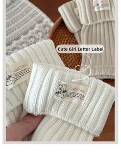 Close-up of knit leg warmer with sometimes letter patch and cute girl label detail