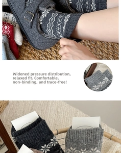 Detail of wool blend socks with Nordic snowflake patterns and ribbed cuffs in gray
