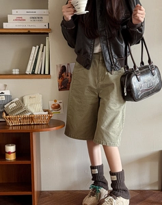 Close-up of Japanese style knitted leg warmers with cloth label and retro sneakers