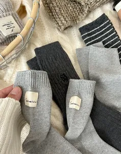 Gros plan détaillé de chaussettes en tricot de coton gris avec bord-côte et broderie