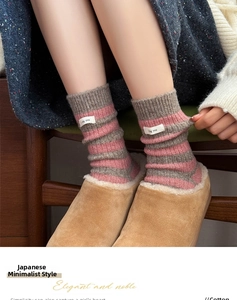 Close-up of wool-blend striped socks with logo patch and warm fuzzy slippers