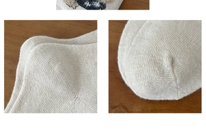 Detail of wool knit socks showing reinforced toe and heel texture on wooden background