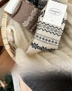 Close-up of thick knitted wool socks with Fair Isle patterns in a rustic woven basket
