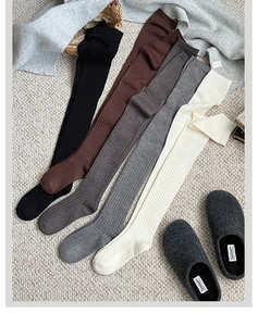 Detailed knit texture of over-knee socks in five colors on a textured beige carpet