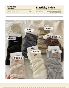 Close-up of thick knitted leg warmers in seven colors with soft ribbed texture and leather tag