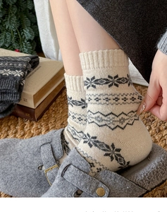 Detail view of cozy wool socks with Fair Isle snowflake patterns and ribbed cuffs
