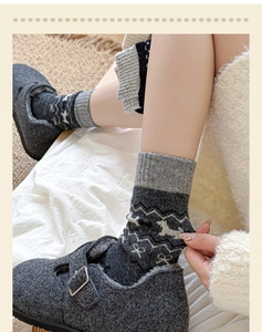 Close-up of Fair Isle wool socks with animal motifs paired with grey buckle shoes