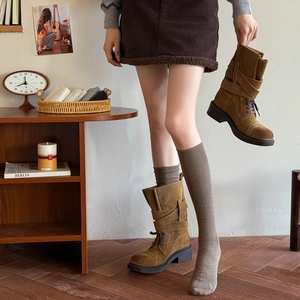 Brown suede mid-calf boots with multiple buckles and platform heels in retro room