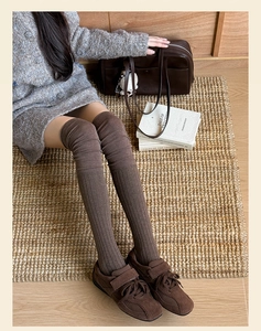Close-up of dark brown vertical ribbed knit over-the-knee socks with a vintage aesthetic