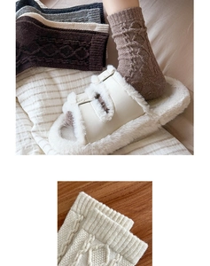 Detail of thick wool cable knit socks in earthy tones showing texture and warm material