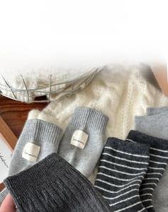 Détail de la texture en tricot de chaussettes grises avec étiquettes sur fond blanc