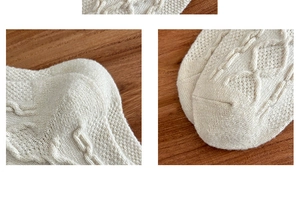 Detailed close-up of cream cable knit wool socks showing reinforced heel and toe texture
