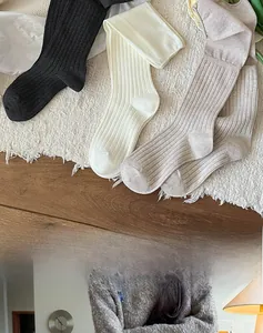 Close-up of knit texture in black, white, and grey calf socks for autumn wear