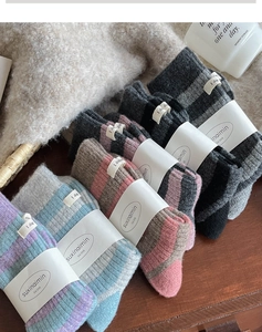 Detailed view of four pairs of striped thick wool socks with retro knit textures and tags