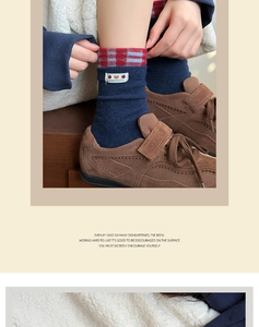 Detail of dark blue socks with plaid cuffs and bear embroidery in brown sneakers