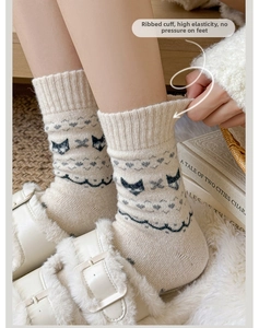 Close-up of flexible ribbed cuffs on Fair Isle wool socks featuring cute cat patterns