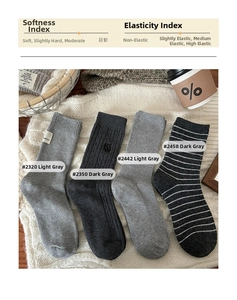 Détail de quatre paires de chaussettes en coton gris aux motifs et teintes variés