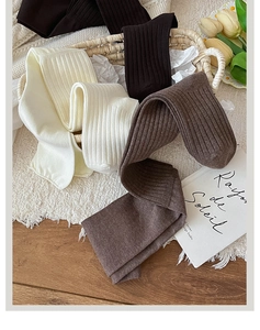 Detailed close-up of ribbed knit over-the-knee socks in cream and brown earthy tones