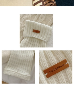 Detail of cream cable-knit leg warmers featuring a vintage brown leather label on the side