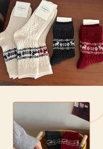 Detailed knit of thick wool socks with Nordic reindeer and snowflake patterns