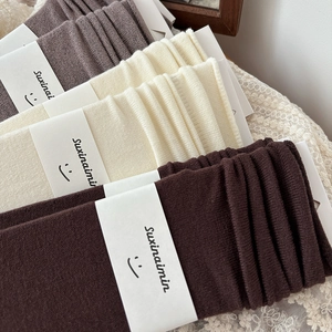 Vintage-Stricksocken in Erdtönen mit minimalistischer Markenverpackung aus Papier