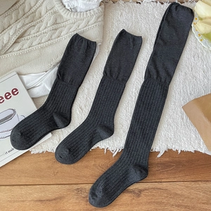 Three lengths of dark grey ribbed knit ballet style stockings in a cozy home setting