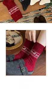 Detailed knit pattern showing Nordic elk and snowflake motifs on wool winter socks
