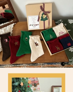 Detailed view of Christmas embroidered crew socks in gift box with festive holiday card
