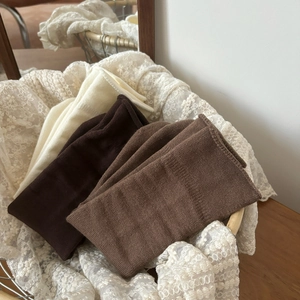Drei Paar Vintage-Stricksocken in Creme und Braun in einem gemütlichen Dekokorb