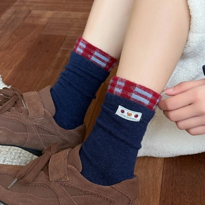 Navy blue crew socks with red plaid cuffs and cute bear patch for autumn and winter