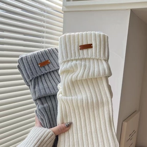 Chunky knit leg warmers in white and grey with vintage leather labels for winter styling